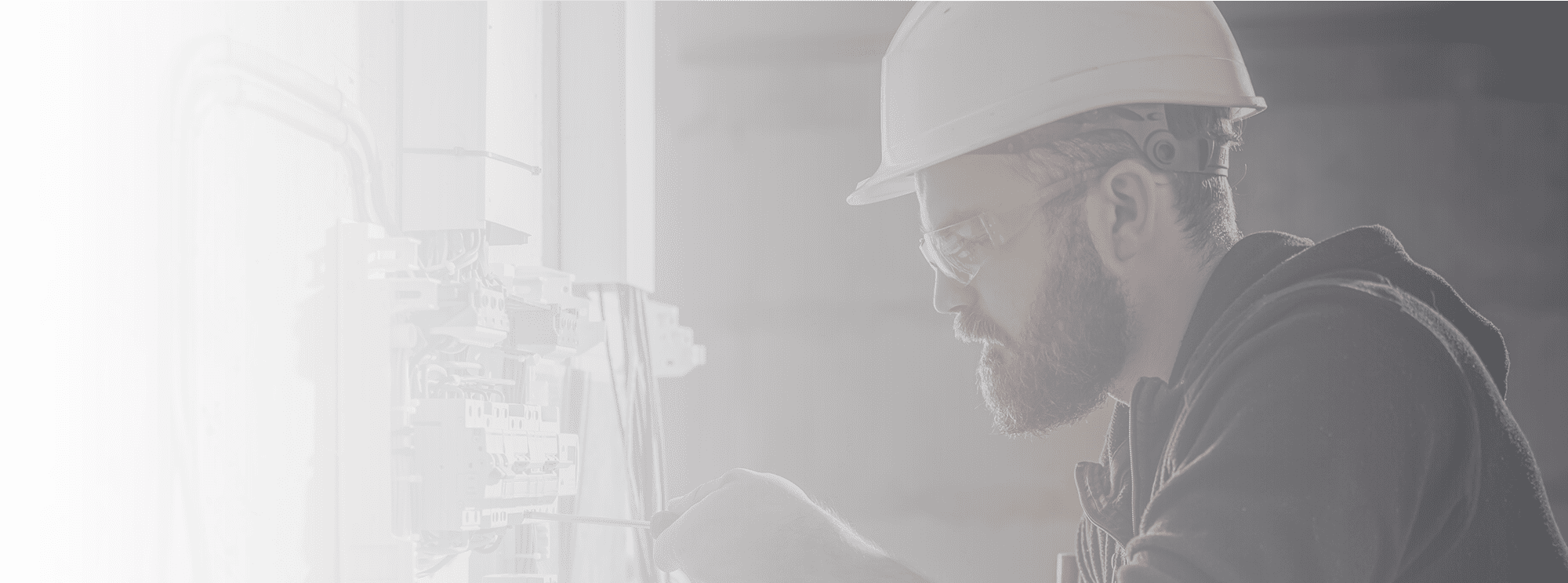 male-electrician-works-in-a-switchboard-with-an-electrical-connecting-cable.png